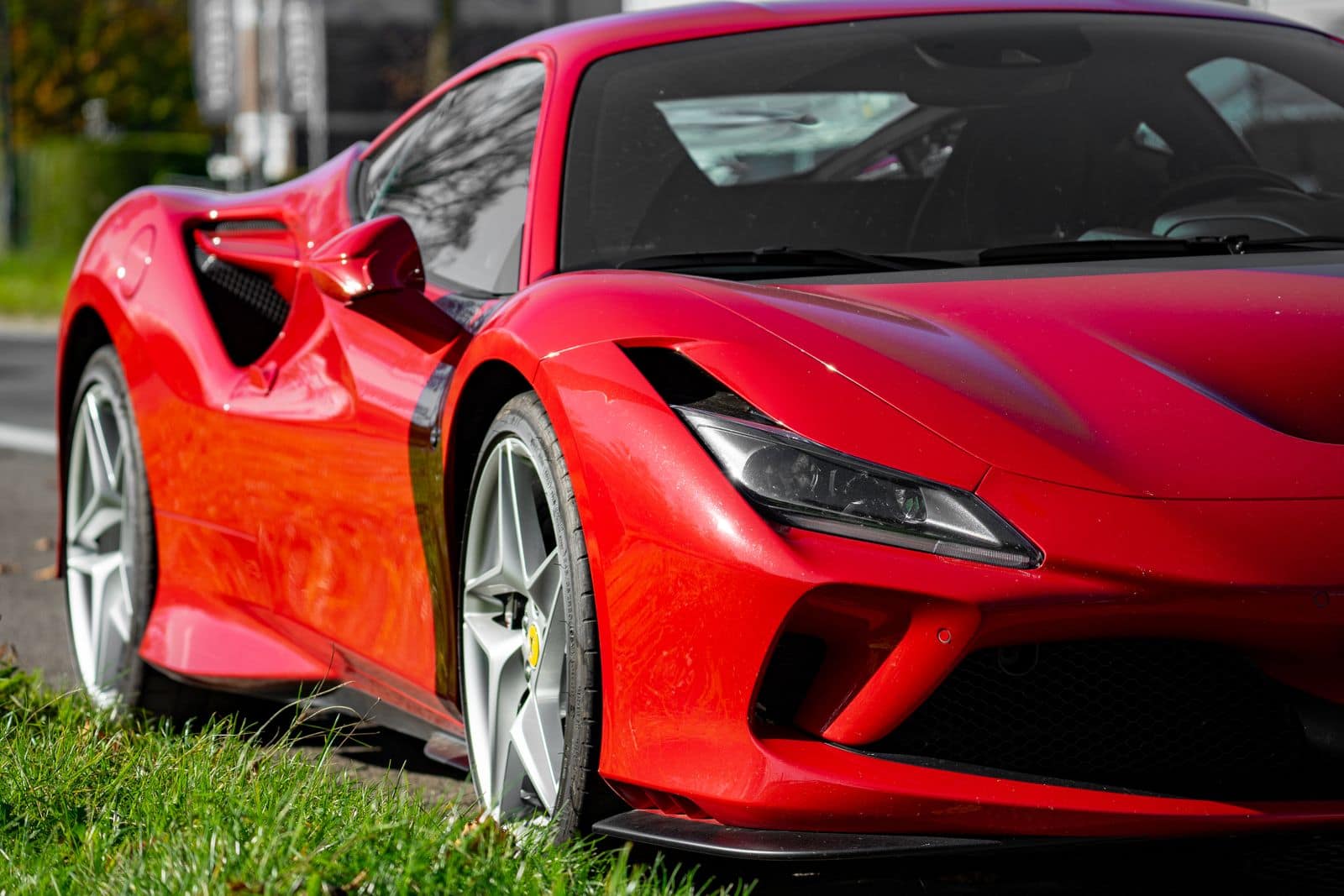 The front quarter of a red Ferrari in dappled sunlight. Photo via Pexels (photo 29126220).
