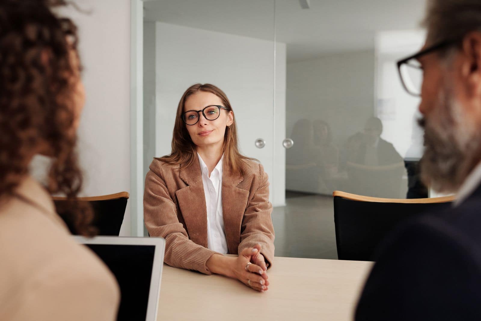 A woman answering questions from a panel across a table, mid interview. Photo via Pexels (photo 4342496).