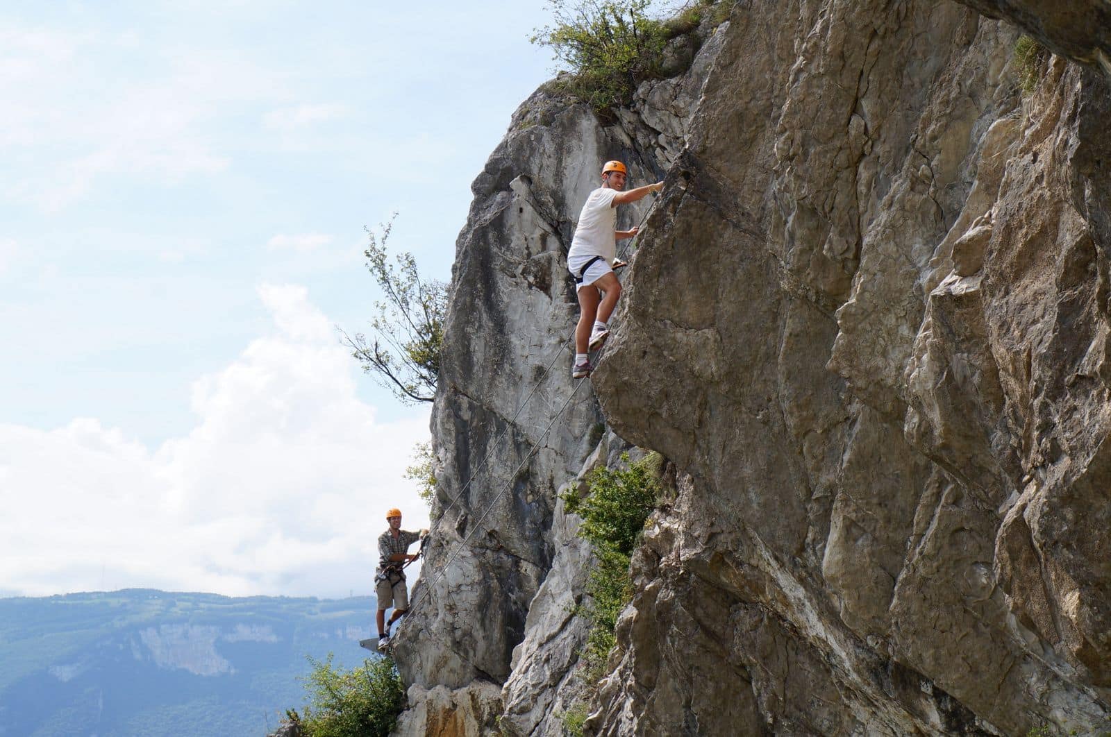 Two climbers working their way up a sheer rock face. Photo via Pexels (photo 9830455).